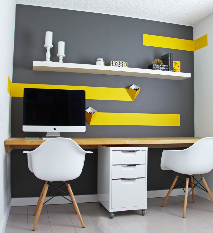 Immagine di un piccolo studio design con pareti multicolore, pavimento in legno verniciato, scrivania incassata e pavimento grigio
