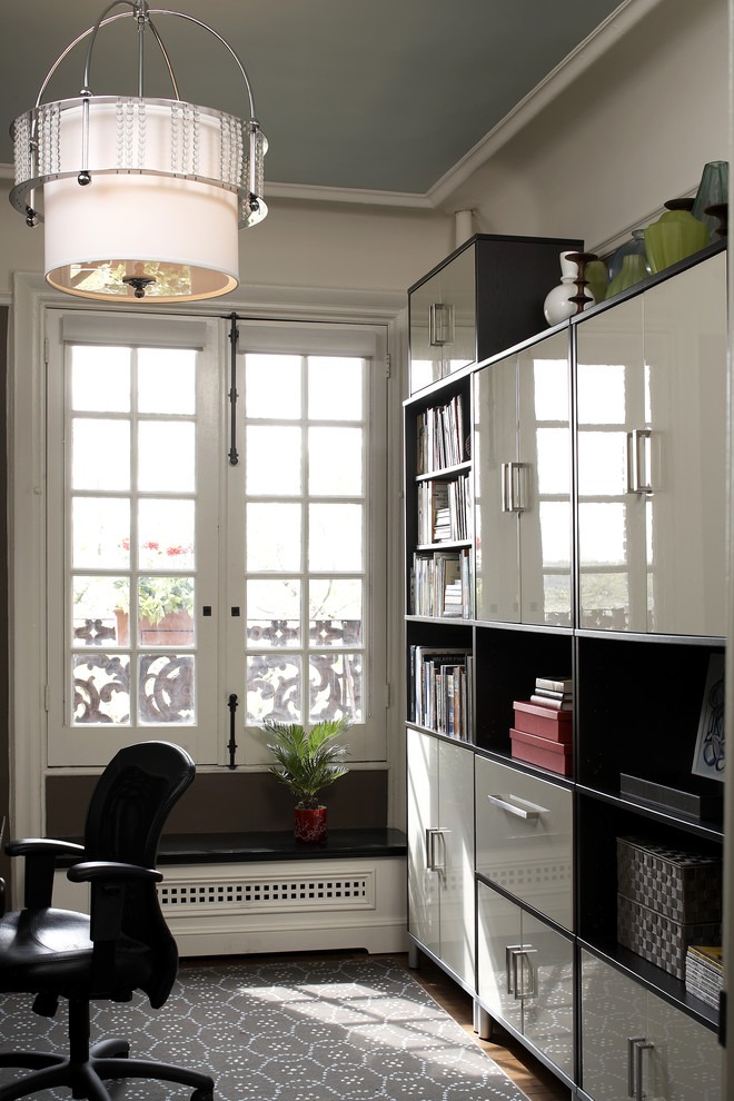 На фото: кабинет в современном стиле с белыми стенами и темным паркетным полом с
