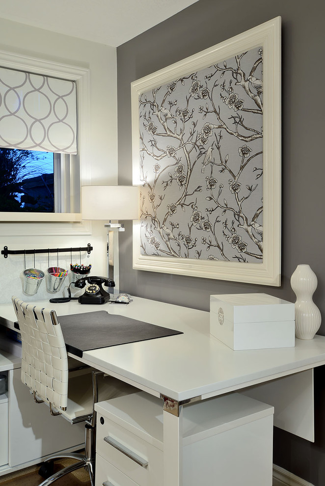 Foto på ett funkis arbetsrum, med grå väggar och ett fristående skrivbord