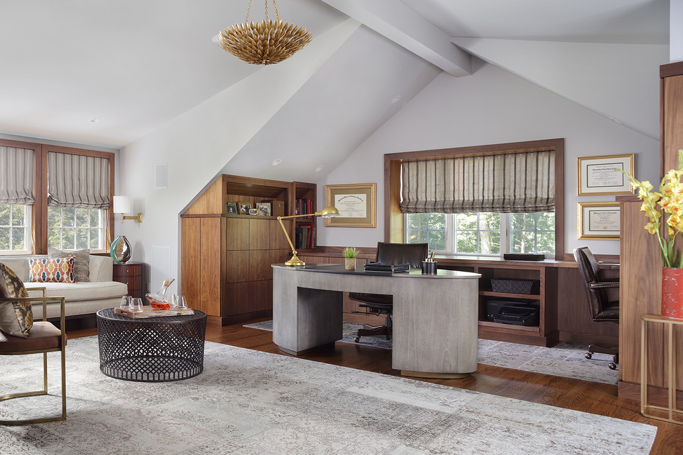 Diseño de despacho actual grande sin chimenea con paredes grises, escritorio independiente, suelo marrón y suelo de madera oscura