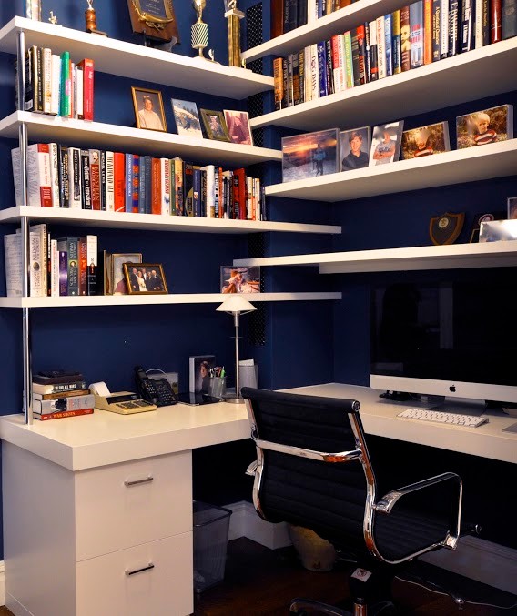 Idee per un piccolo studio minimal con pareti blu, parquet scuro, scrivania incassata e pavimento marrone