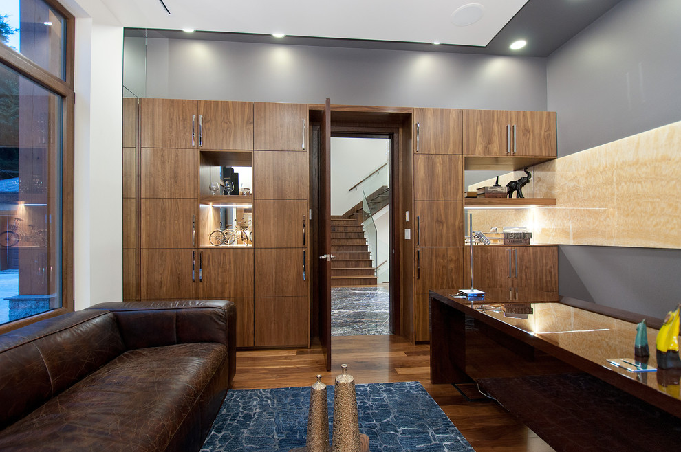 Стильный дизайн: кабинет в современном стиле с серыми стенами, темным паркетным полом и отдельно стоящим рабочим столом - последний тренд
