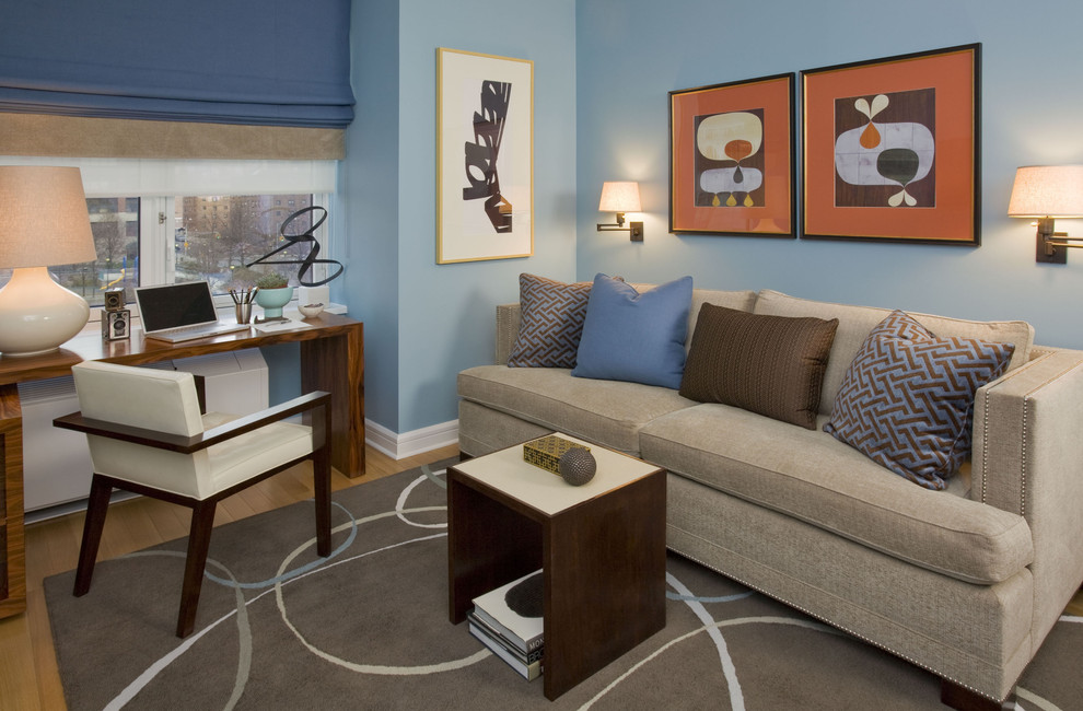 Mittelgroßes Modernes Arbeitszimmer mit blauer Wandfarbe, braunem Holzboden und freistehendem Schreibtisch in New York