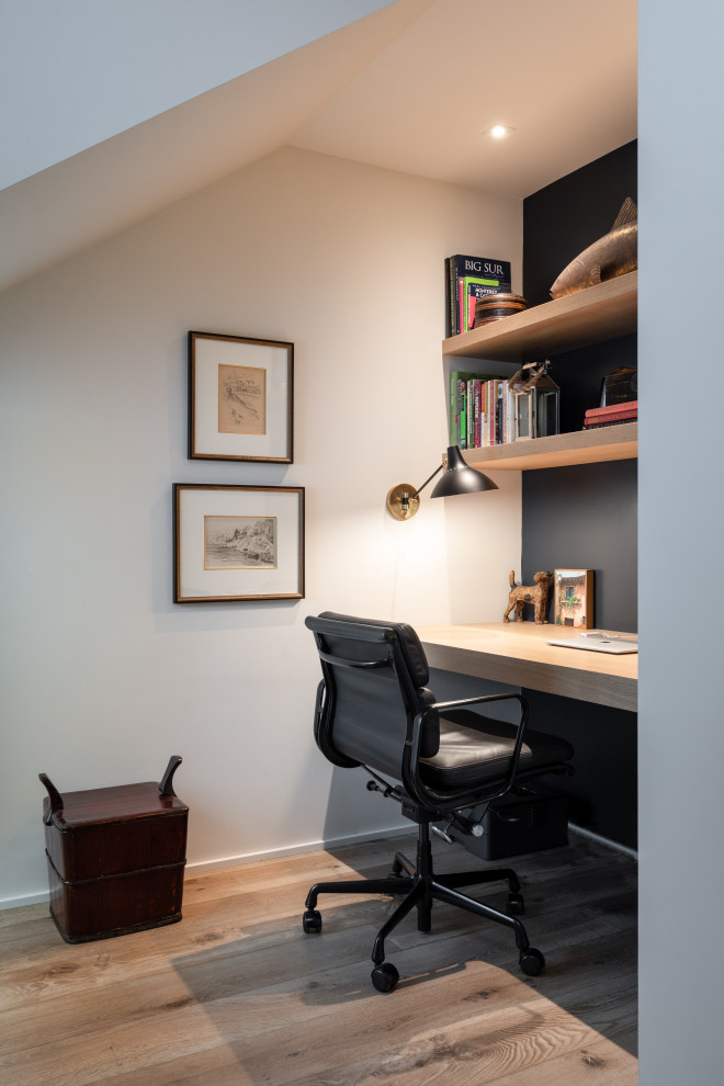 Ejemplo de despacho abovedado actual pequeño con paredes azules, suelo de madera en tonos medios, escritorio empotrado y suelo marrón