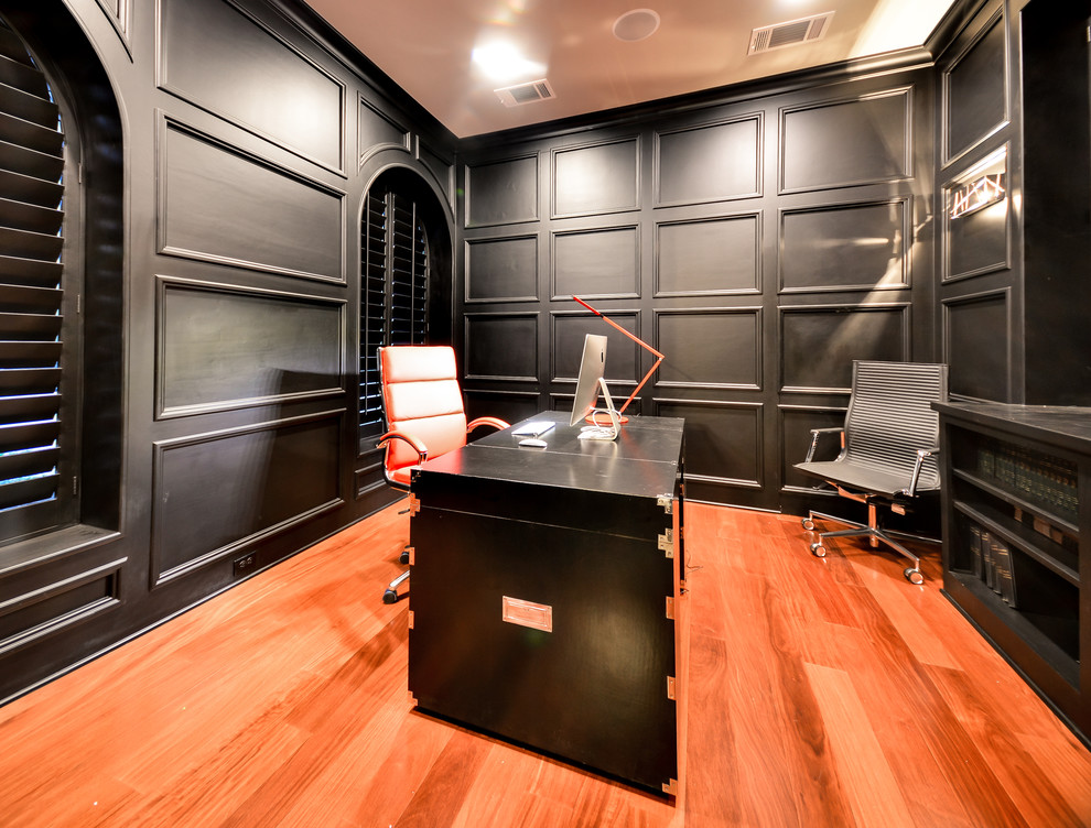 Idéer för att renovera ett stort funkis hemmastudio, med svarta väggar, mellanmörkt trägolv, ett fristående skrivbord och brunt golv
