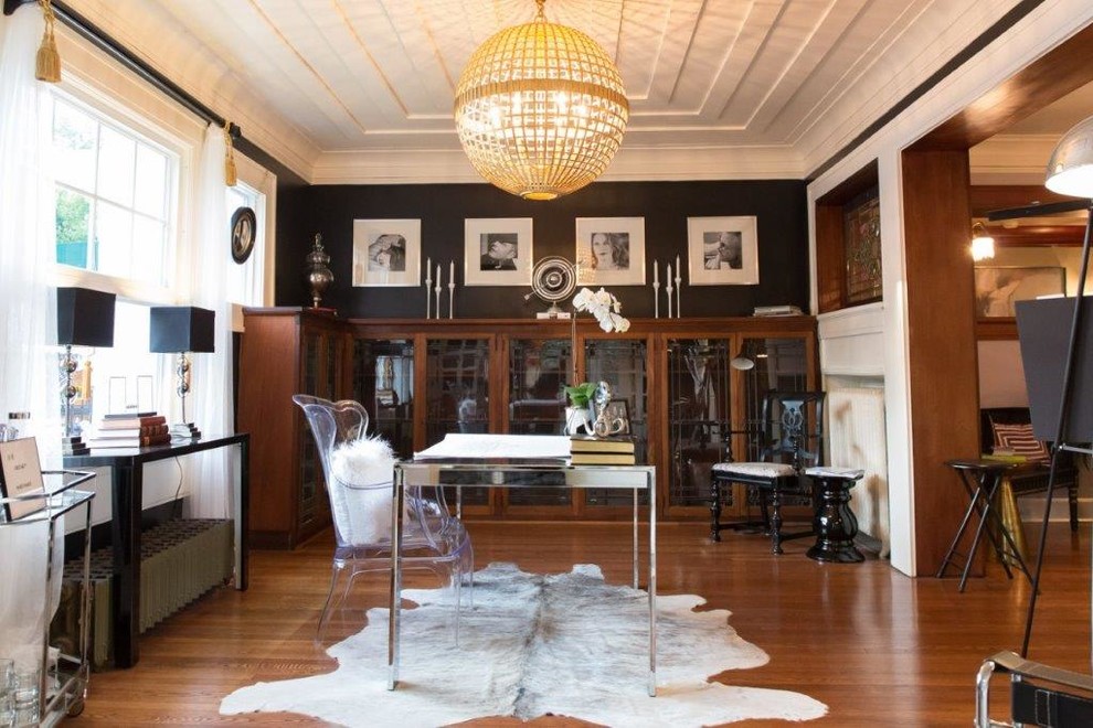 Foto de despacho contemporáneo de tamaño medio con suelo de madera en tonos medios, escritorio independiente y paredes negras