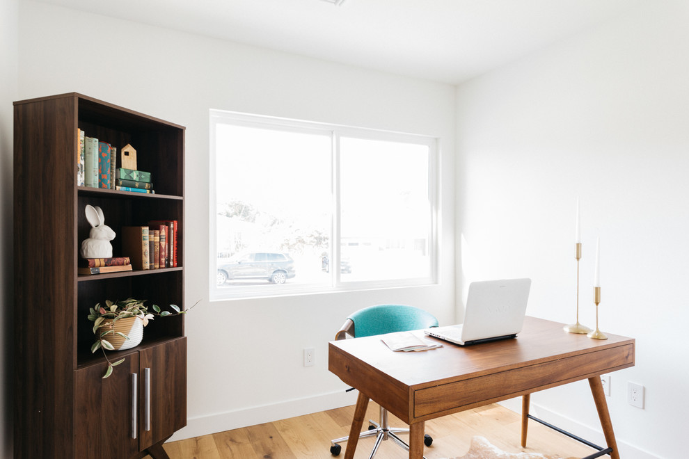 Ejemplo de despacho tradicional renovado sin chimenea con paredes blancas, suelo de madera clara y escritorio independiente