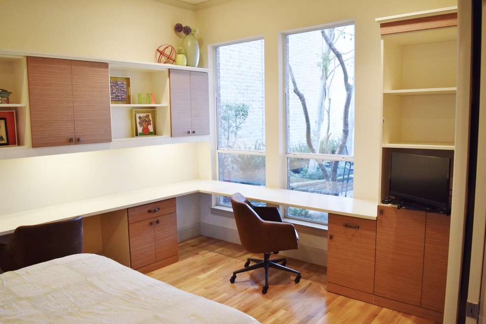 Example of a large trendy built-in desk light wood floor study room design in Dallas with white walls and no fireplace