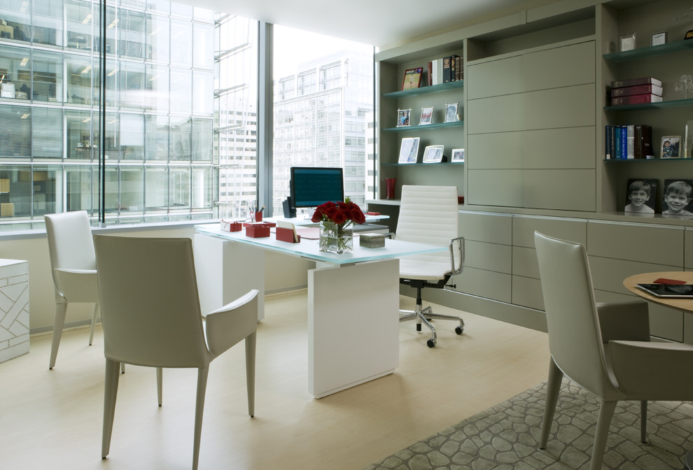 Ejemplo de despacho contemporáneo de tamaño medio sin chimenea con paredes beige, escritorio independiente, suelo beige y suelo de madera clara