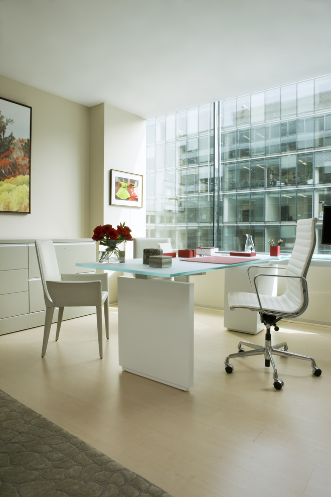 Imagen de despacho actual de tamaño medio sin chimenea con paredes beige, suelo laminado, escritorio independiente y suelo beige