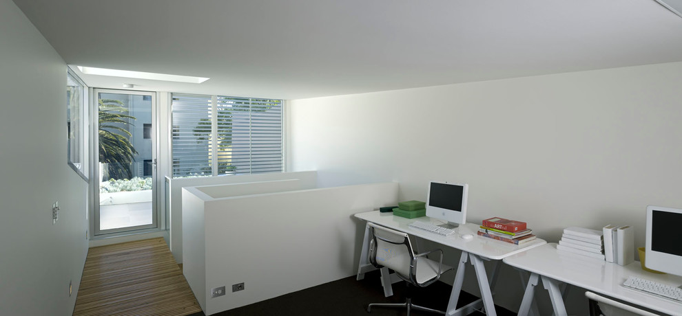 Aménagement d'un bureau contemporain avec un mur blanc, parquet clair et un bureau indépendant.