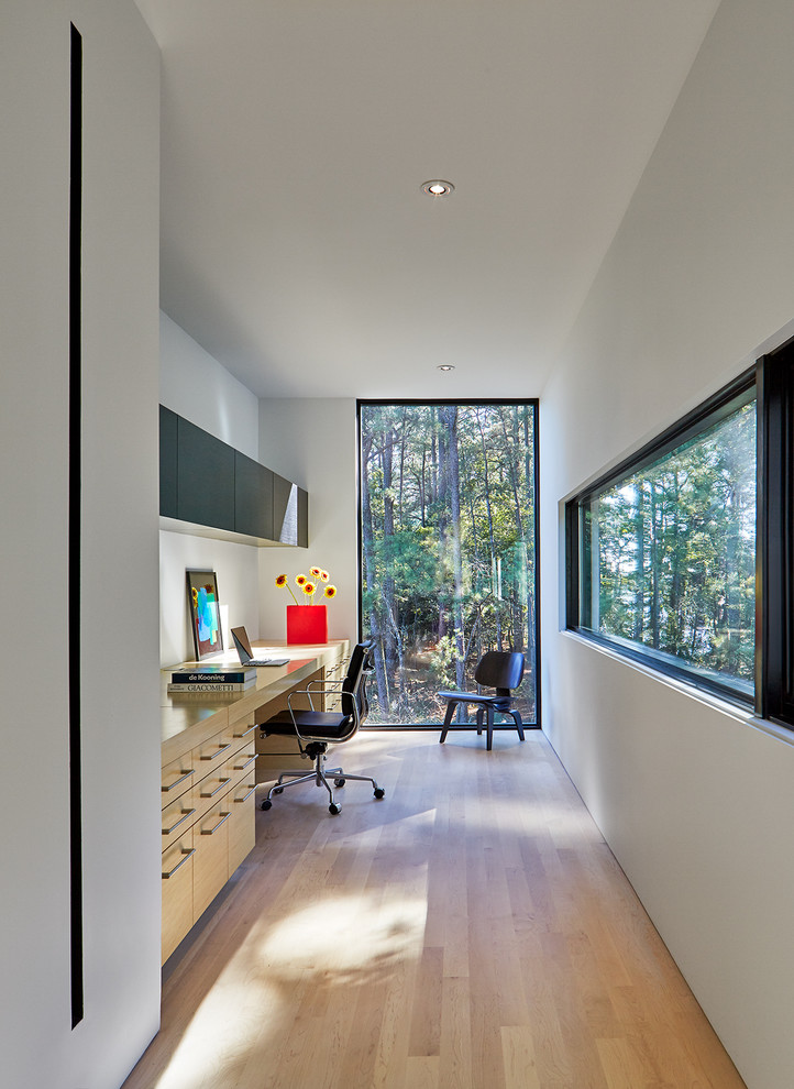 Idee per un ufficio minimal con pareti bianche, parquet chiaro, nessun camino e scrivania incassata