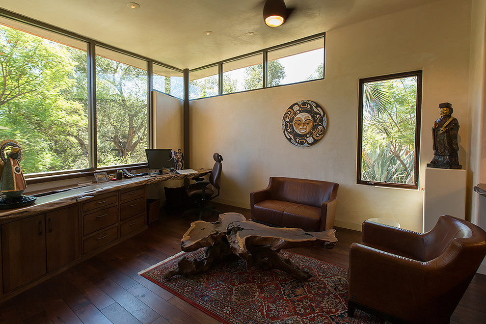 Diseño de estudio actual de tamaño medio sin chimenea con paredes beige, suelo de madera oscura y escritorio empotrado