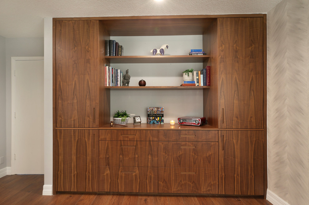 Foto di uno studio minimal di medie dimensioni con libreria, pareti grigie, pavimento in laminato, scrivania autoportante e pavimento marrone