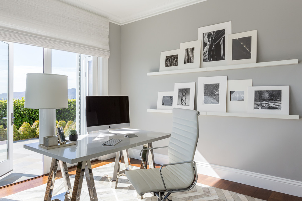 Idée de décoration pour un bureau design de taille moyenne avec un mur gris, un sol en bois brun, aucune cheminée et un bureau indépendant.
