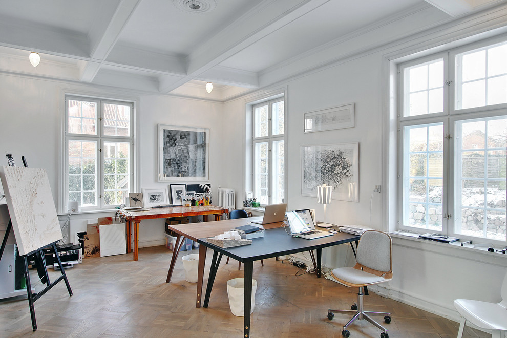 Mittelgroßes Modernes Arbeitszimmer mit Studio, weißer Wandfarbe, braunem Holzboden und freistehendem Schreibtisch in Kopenhagen