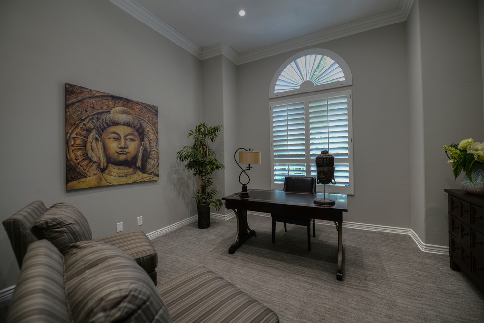 This is an example of a medium sized classic study in Orange County with grey walls, carpet and a freestanding desk.