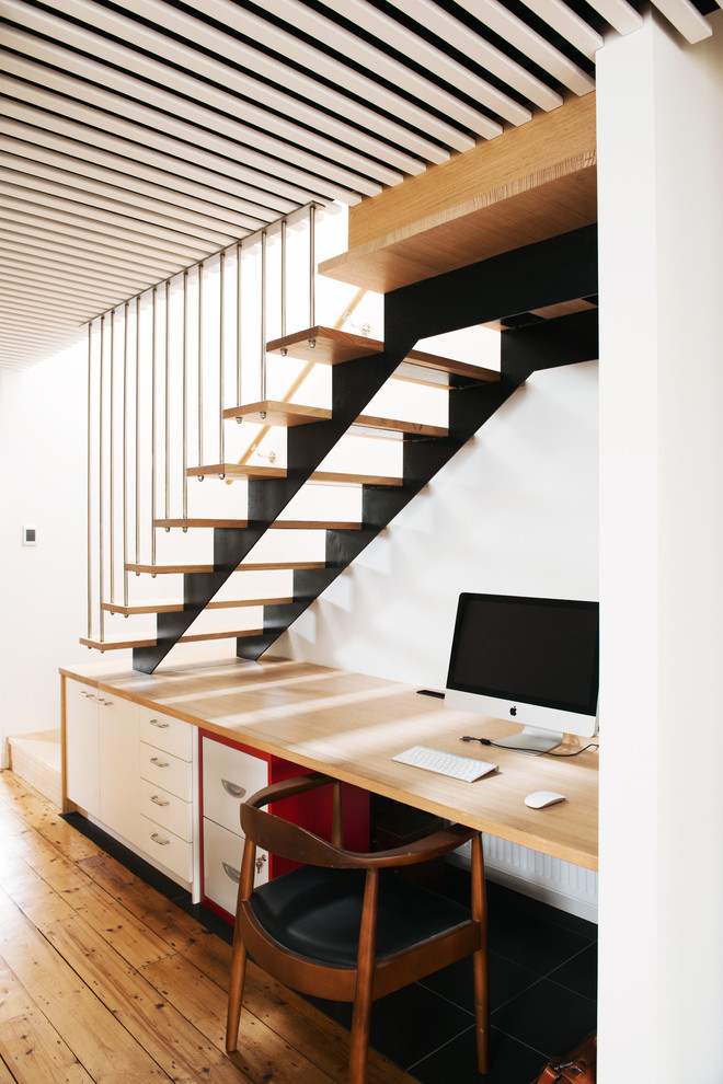 Diseño de despacho nórdico de tamaño medio con paredes blancas, suelo de madera en tonos medios y escritorio empotrado