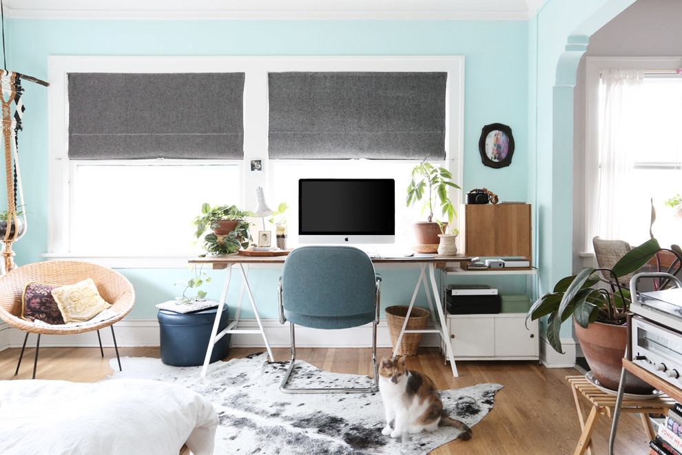 Inspiration för små moderna hemmastudior, med blå väggar, mellanmörkt trägolv och ett fristående skrivbord
