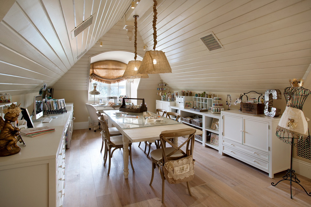 Shabby-chic style home studio in Phoenix with beige walls, light hardwood flooring, a freestanding desk and beige floors.