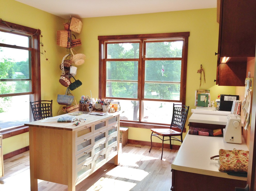 Example of a mid-sized arts and crafts built-in desk light wood floor craft room design in Minneapolis