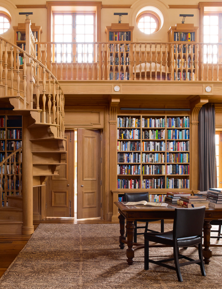 Idee per uno studio tradizionale con libreria, scrivania autoportante, pareti beige e pavimento in legno massello medio