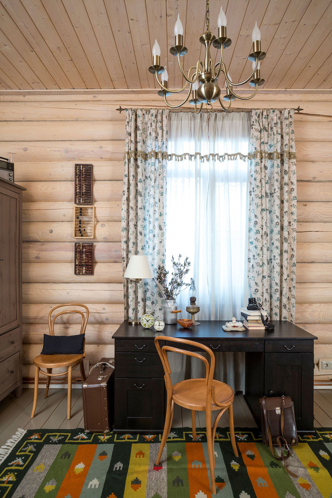 Landhaus Arbeitszimmer mit Arbeitsplatz, beiger Wandfarbe, gebeiztem Holzboden und freistehendem Schreibtisch in Moskau