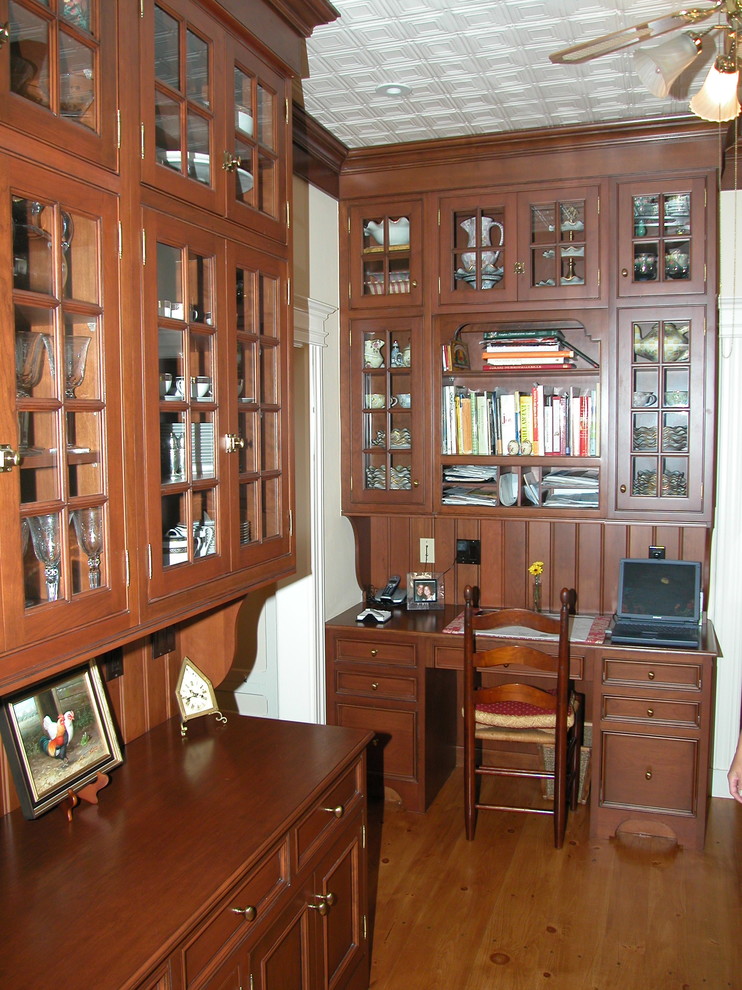 Esempio di un ufficio tradizionale di medie dimensioni con pavimento in legno massello medio e scrivania incassata