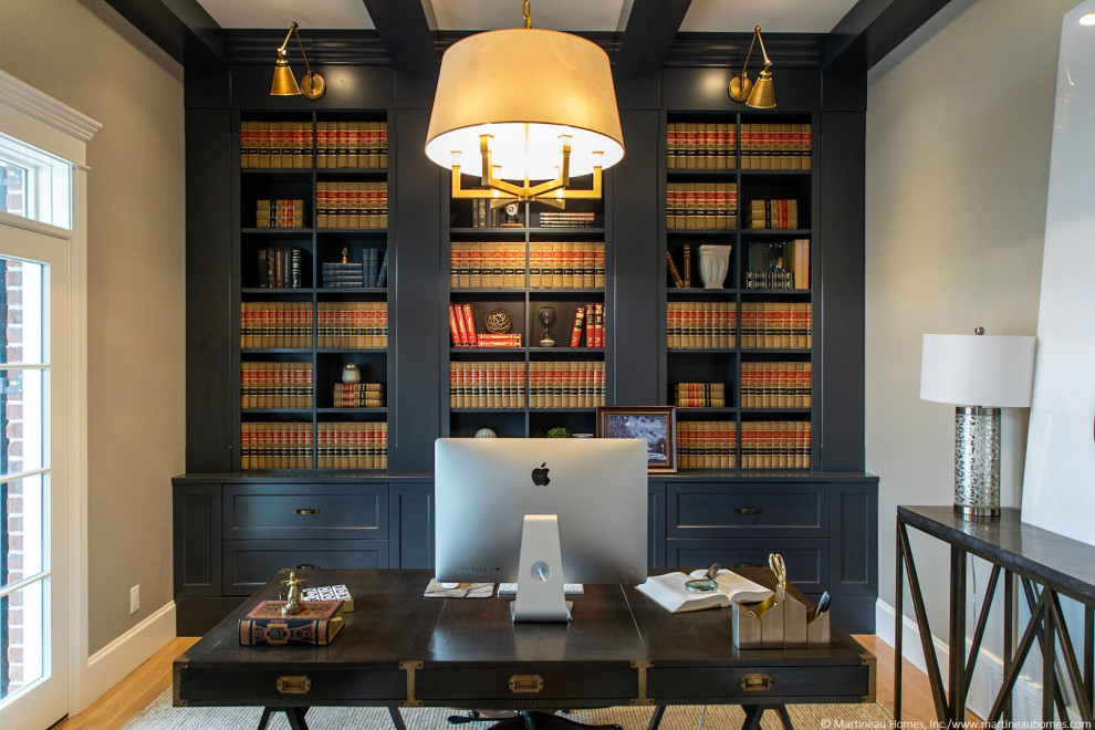 Modelo de despacho tradicional renovado de tamaño medio sin chimenea con paredes grises, suelo de madera en tonos medios, escritorio independiente, suelo marrón y vigas vistas