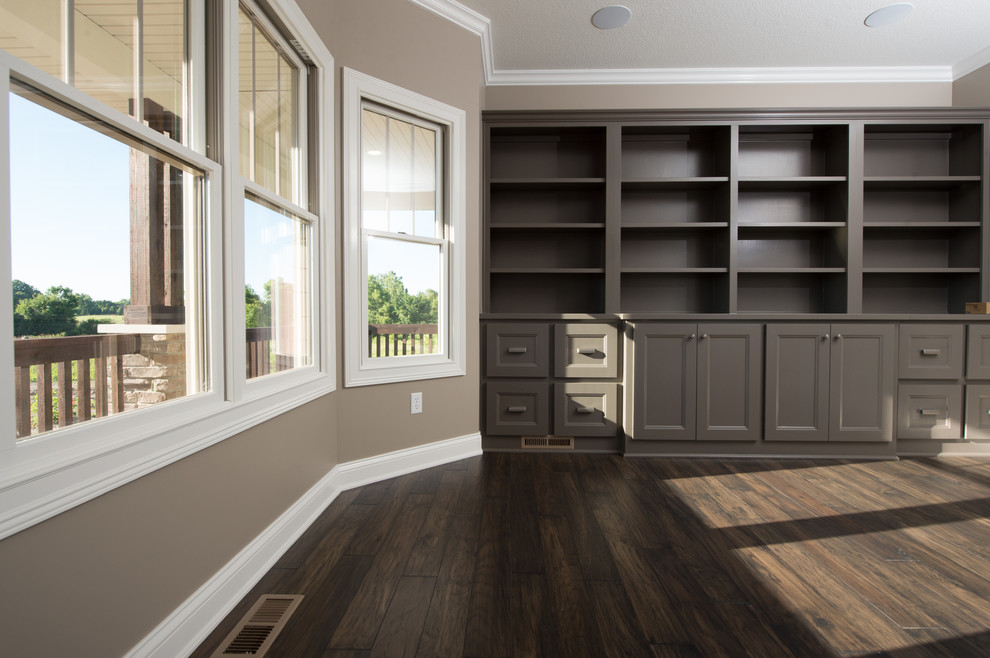 Example of a large dark wood floor home office library design in Other with beige walls and no fireplace