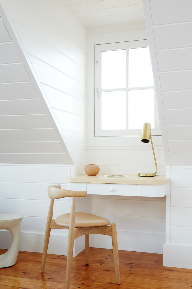 Idée de décoration pour un petit bureau marin avec un mur blanc, un sol en bois brun et un bureau intégré.
