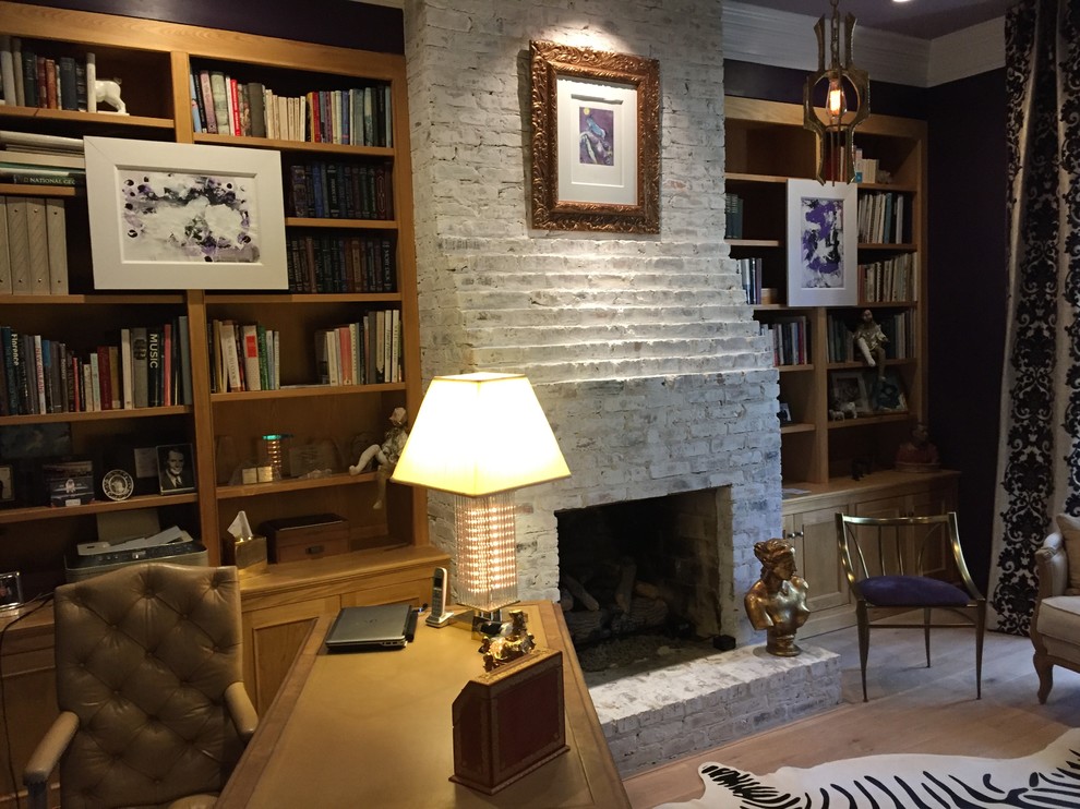 Idéer för mellanstora vintage hemmabibliotek, med bruna väggar, ljust trägolv, en standard öppen spis, en spiselkrans i tegelsten och ett fristående skrivbord