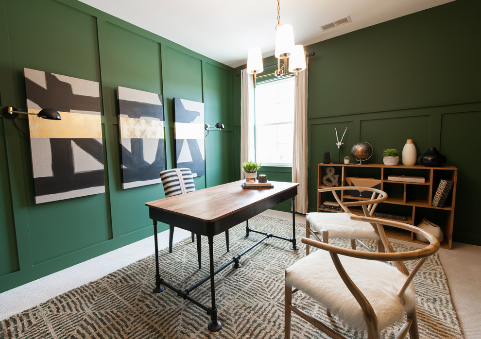 Inredning av ett modernt hemmabibliotek, med gröna väggar, heltäckningsmatta, ett fristående skrivbord och beiget golv