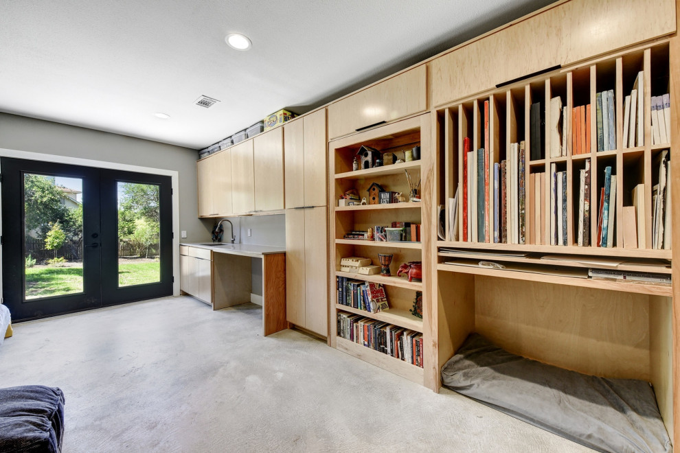 Mittelgroßes Modernes Arbeitszimmer mit Studio, hellem Holzboden, Einbau-Schreibtisch und beigem Boden in Austin