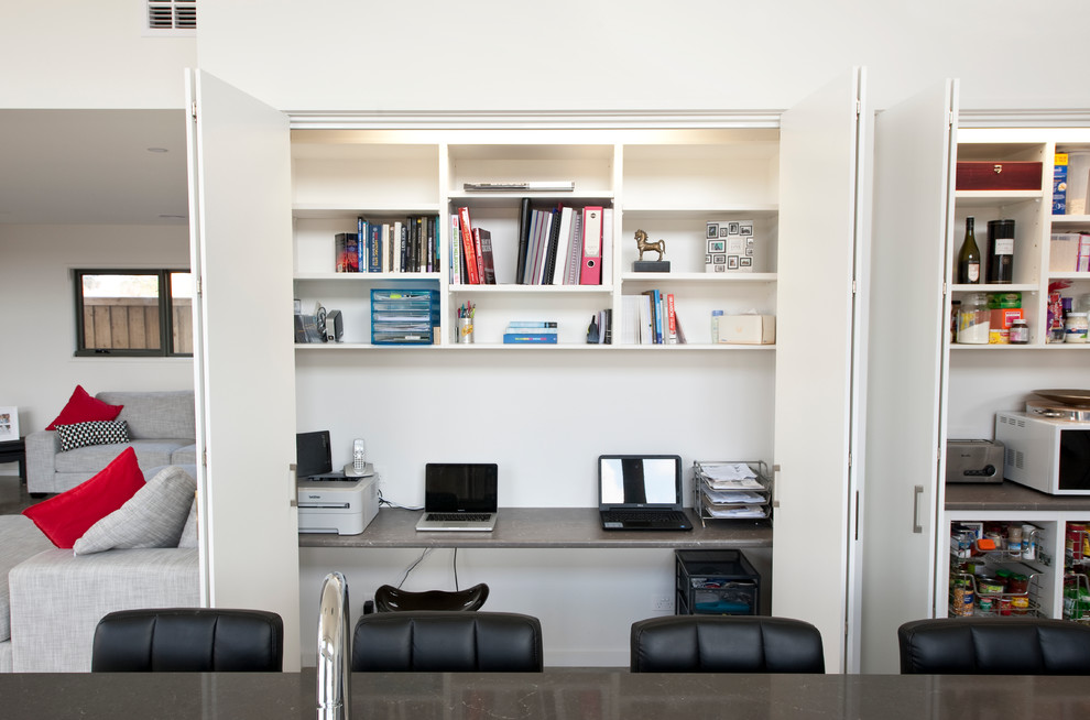 ジーロングにある低価格の小さなコンテンポラリースタイルのおしゃれなホームオフィス・書斎 (白い壁、コンクリートの床、造り付け机) の写真