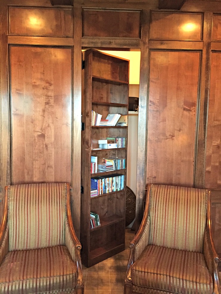 Idéer för ett stort klassiskt hemmabibliotek, med bruna väggar, mellanmörkt trägolv och ett fristående skrivbord