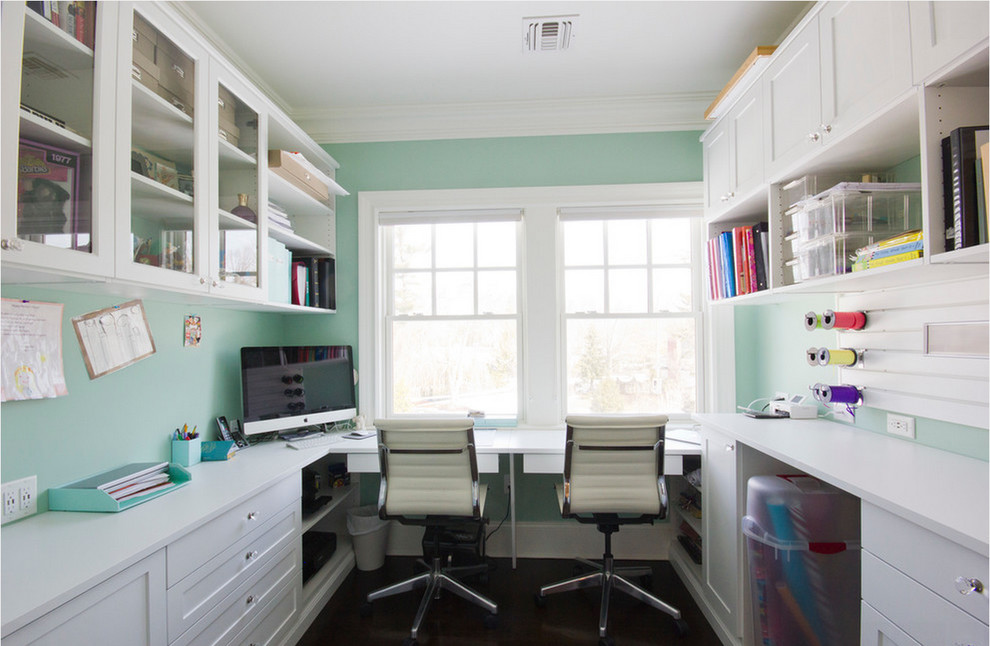 Foto på ett stort funkis hobbyrum, med blå väggar, mörkt trägolv och ett inbyggt skrivbord