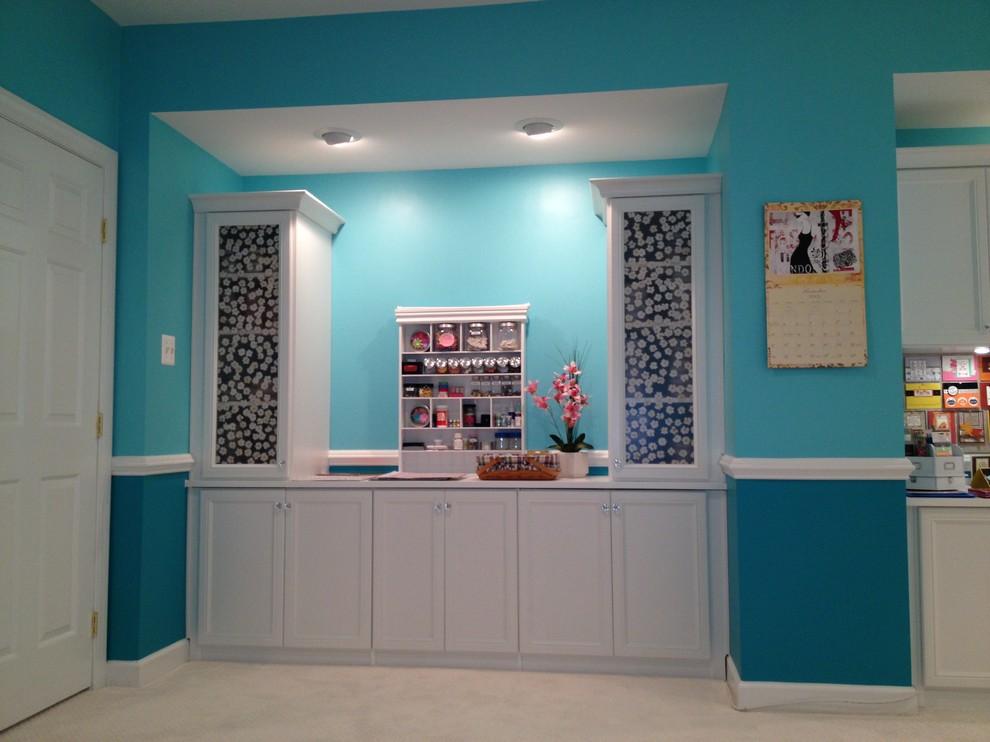Aménagement d'un grand bureau atelier classique avec un mur bleu, moquette, un bureau intégré et un sol marron.