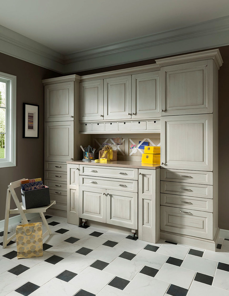 Diseño de sala de manualidades tradicional de tamaño medio con paredes beige, suelo de mármol, escritorio empotrado y suelo blanco