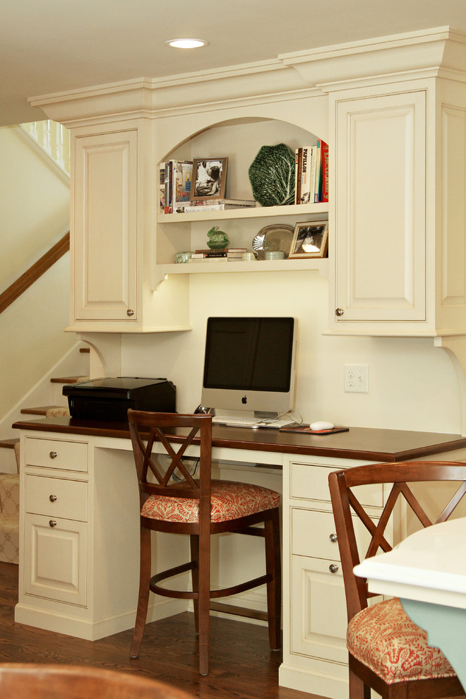 Foto di uno studio american style con pareti beige, scrivania incassata e pavimento in legno massello medio