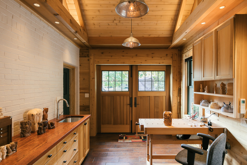 Kleines Landhausstil Arbeitszimmer ohne Kamin mit Studio, brauner Wandfarbe, dunklem Holzboden, freistehendem Schreibtisch und braunem Boden in Atlanta