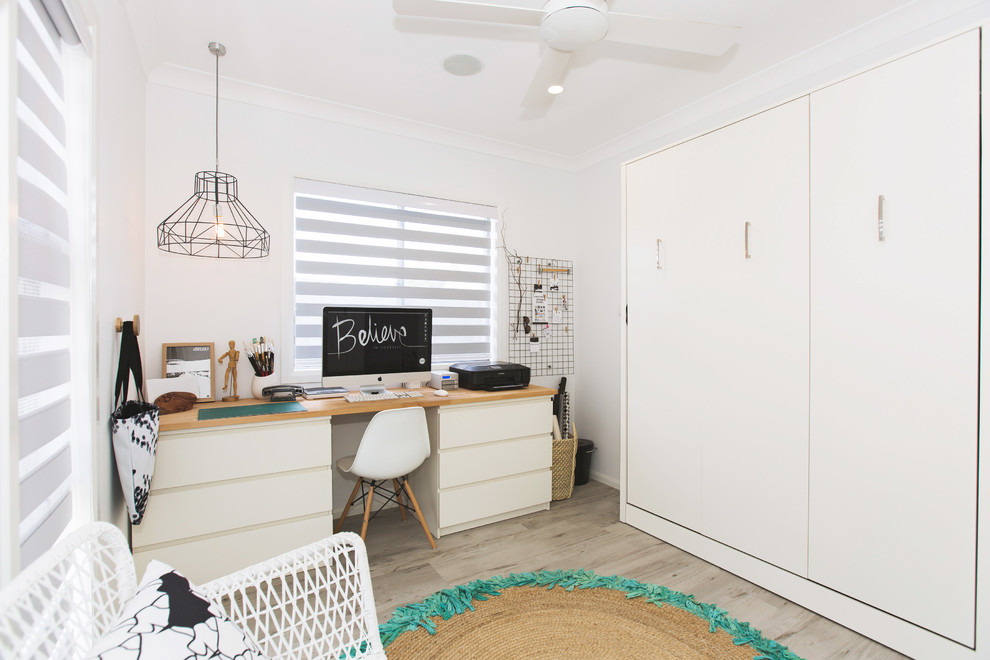 Idéer för ett minimalistiskt hemmastudio, med vita väggar, vinylgolv och ett fristående skrivbord