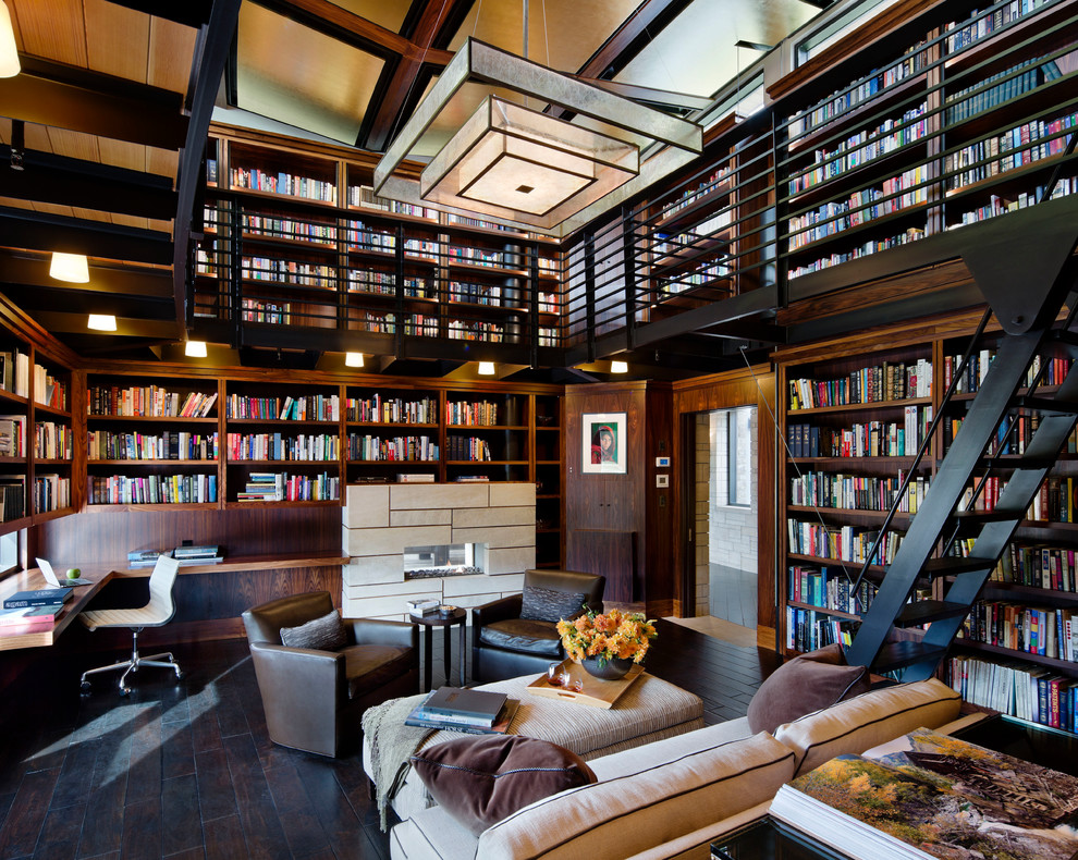 Источник вдохновения для домашнего уюта: огромный домашняя библиотека в современном стиле с темным паркетным полом, встроенным рабочим столом, черным полом, коричневыми стенами, горизонтальным камином и фасадом камина из плитки