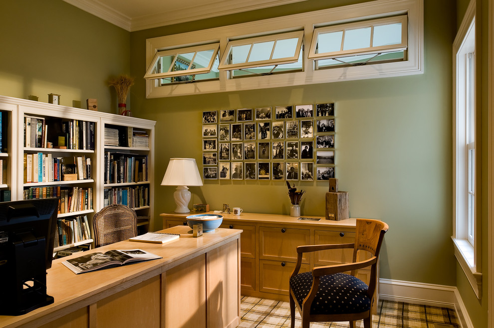 Immagine di uno studio classico con pareti verdi, moquette e scrivania autoportante