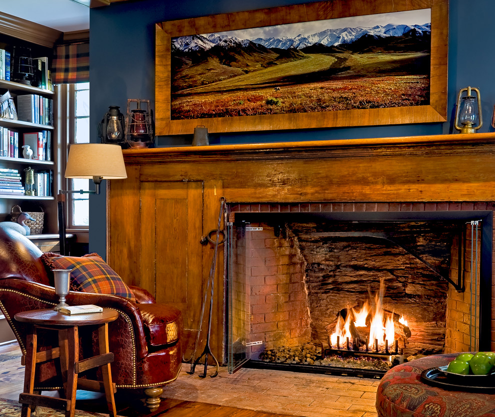 Klassisches Arbeitszimmer mit blauer Wandfarbe, braunem Holzboden, Kaminumrandung aus Backstein und Kamin in New York