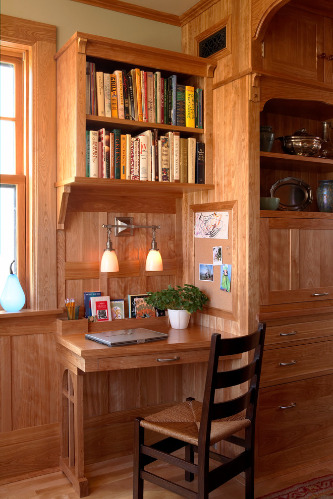 Cette photo montre un bureau craftsman avec un bureau intégré, un sol en bois brun, un mur beige et aucune cheminée.