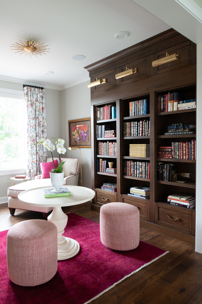 Cette photo montre un bureau chic de taille moyenne avec une bibliothèque ou un coin lecture, un mur gris, aucune cheminée, un sol marron et parquet foncé.