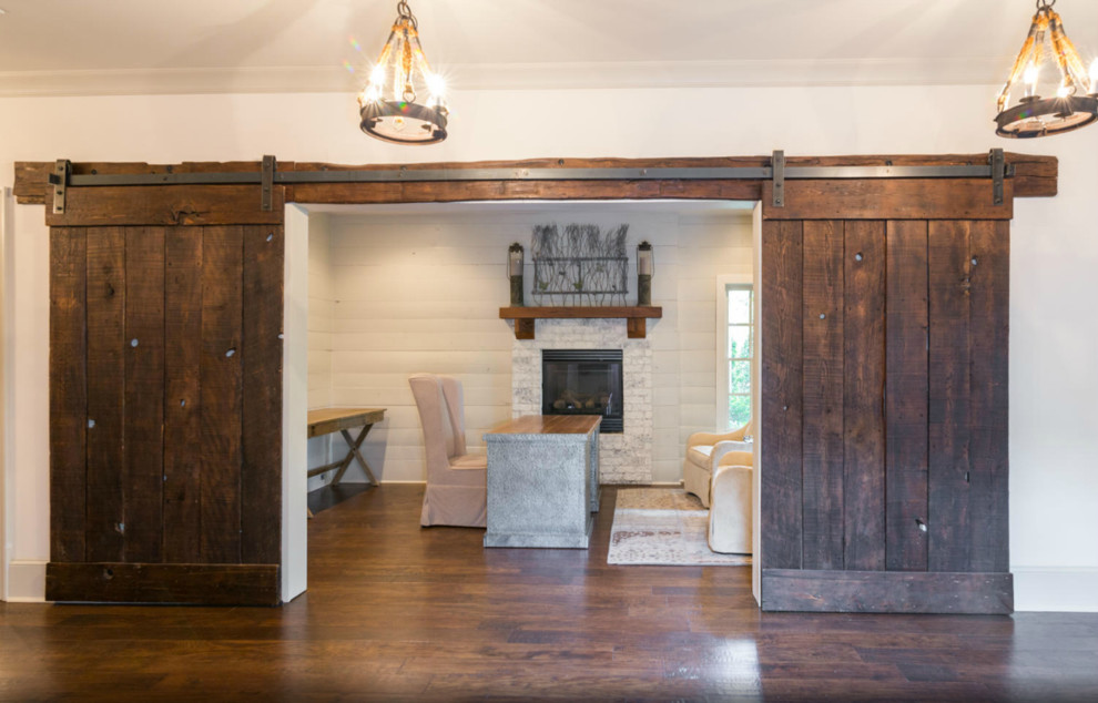 Large arts and crafts freestanding desk medium tone wood floor home office photo in Atlanta with white walls, a standard fireplace and a brick fireplace