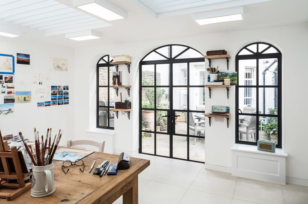 Diseño de despacho tradicional renovado con paredes blancas, escritorio independiente y suelo beige