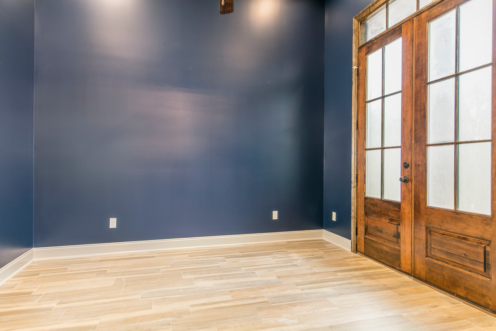 Mittelgroßes Klassisches Arbeitszimmer ohne Kamin mit Arbeitsplatz, blauer Wandfarbe, Vinylboden und beigem Boden in New Orleans